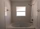 Bathroom featuring a bathtub, shower, and toilet with white tile throughout at 223 Lady Diana Dr, Davenport, FL 33837