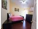 Bedroom with ceiling fan and wooden furniture with pink bedding and wood floors at 223 Lady Diana Dr, Davenport, FL 33837