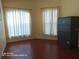 The empty bedroom has wood floors, yellow walls, a bright window with curtains at 223 Lady Diana Dr, Davenport, FL 33837