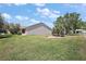 Spacious backyard featuring lush green lawn and a mature tree at 2290 Due West Dr, The Villages, FL 32162