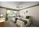 Bright bedroom features twin beds, ceiling fan, and a large window letting in natural light at 2290 Due West Dr, The Villages, FL 32162