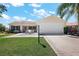 Charming single-story home with a well-manicured lawn, inviting patio, and two-car garage on a sunny day at 2290 Due West Dr, The Villages, FL 32162