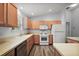 Functional kitchen with light wood cabinets, white appliances, ample counter space, and modern flooring at 2290 Due West Dr, The Villages, FL 32162