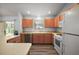 Well-maintained kitchen featuring light wood cabinets, white appliances, modern flooring, and bright natural light at 2290 Due West Dr, The Villages, FL 32162