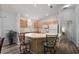 Open kitchen design with light wood cabinets, white appliances, a breakfast bar, and contemporary flooring at 2290 Due West Dr, The Villages, FL 32162