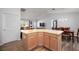 Stylish kitchen island with a breakfast bar, light wood cabinets, modern flooring, and views into the living and dining areas at 2290 Due West Dr, The Villages, FL 32162