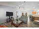 Bright living room featuring a ceiling fan, comfortable seating, and modern flooring leading to the dining area and kitchen at 2290 Due West Dr, The Villages, FL 32162