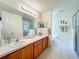 Bathroom featuring a dual sink vanity and a large mirror at 25044 Cranes Roost Cir, Leesburg, FL 34748