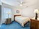 Comfortable bedroom featuring a ceiling fan and large window at 25044 Cranes Roost Cir, Leesburg, FL 34748