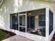 Exterior view of the screened lanai with white siding and lush landscaping at 25044 Cranes Roost Cir, Leesburg, FL 34748