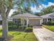 Charming home featuring a well-manicured lawn, neat shrubbery, and an attached garage at 25044 Cranes Roost Cir, Leesburg, FL 34748