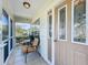 Close up of a screened in front porch with tile flooring and seating at 25044 Cranes Roost Cir, Leesburg, FL 34748