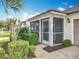 The home has a screened in front porch with neutral trim and a storm door at 25044 Cranes Roost Cir, Leesburg, FL 34748