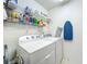 Functional laundry area with washer, dryer, and storage shelves for cleaning supplies at 25044 Cranes Roost Cir, Leesburg, FL 34748