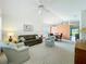 Bright living room featuring a ceiling fan, plush carpeting, and an open floor plan at 25044 Cranes Roost Cir, Leesburg, FL 34748
