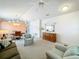 Bright living room featuring plush carpeting, a ceiling fan and a view of the dining area at 25044 Cranes Roost Cir, Leesburg, FL 34748