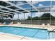 Enjoy a refreshing swim in this sparkling pool with a screened enclosure and ample seating at 25044 Cranes Roost Cir, Leesburg, FL 34748