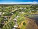 Panoramic aerial view of a residential area with dense tree coverage and a picturesque lake at 25540 Belle Helene, Leesburg, FL 34748