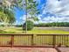 View from the back deck overlooking a lush green field and clear blue skies with scattered clouds at 25540 Belle Helene, Leesburg, FL 34748