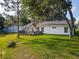 Expansive backyard with a well-maintained lawn and a lovely back deck adorned with plants and flowers at 25540 Belle Helene, Leesburg, FL 34748