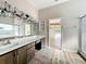 Bright bathroom featuring a dual vanity, striking light fixtures, and a walk-in shower at 25540 Belle Helene, Leesburg, FL 34748