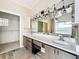 Bright bathroom featuring a dual vanity, striking light fixtures, and a walk-in closet for ample storage at 25540 Belle Helene, Leesburg, FL 34748