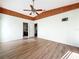 Bedroom with hardwood floors, ceiling fan, wooden trim, and an open entrance to other rooms at 25540 Belle Helene, Leesburg, FL 34748