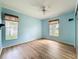 Bedroom featuring hardwood floors, a ceiling fan, with natural lighting coming from the two windows at 25540 Belle Helene, Leesburg, FL 34748