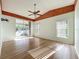 Bedroom with hardwood floors, ceiling fan, wooden trim, and a sliding door to the outdoor patio at 25540 Belle Helene, Leesburg, FL 34748