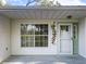 Welcoming front entrance featuring a decorative glass door, window, and siding detail at 25540 Belle Helene, Leesburg, FL 34748