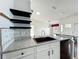 Modern kitchen with granite countertops, a stainless steel sink and open shelving at 25540 Belle Helene, Leesburg, FL 34748
