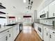 Bright kitchen with white cabinetry, updated appliances, and an island with granite countertops at 25540 Belle Helene, Leesburg, FL 34748