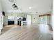 Open-concept living area featuring wood-look flooring, stylish pendant lights, and a modern kitchen at 25540 Belle Helene, Leesburg, FL 34748