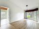 Bright living room with wood-look floors, large windows, and an open doorway at 25540 Belle Helene, Leesburg, FL 34748