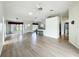 Open-concept living area featuring hardwood floors, a ceiling fan, an adjacent kitchen, and natural light at 25540 Belle Helene, Leesburg, FL 34748