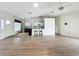 Bright open-concept living room with hardwood floors, a ceiling fan, and adjacent kitchen area at 25540 Belle Helene, Leesburg, FL 34748