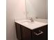 Bathroom vanity with white counter and dark wood cabinets; chrome fixtures at 27 Perch Dr, Kissimmee, FL 34759