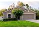 Charming single-Gathering home featuring a well-manicured lawn, complemented by a mature tree in the front yard at 27 Perch Dr, Kissimmee, FL 34759
