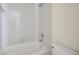 Bathroom with a tiled shower and tub combo, and a white toilet at 2934 Tangerine Ct, Leesburg, FL 34748
