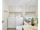Bright bathroom features white cabinets, sink, toilet and washer/dryer at 2934 Tangerine Ct, Leesburg, FL 34748