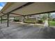 Designated carport parking featuring a paved surface and manicured landscaping enhancing its outdoor appeal at 2934 Tangerine Ct, Leesburg, FL 34748