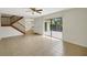 Open-concept living room features tiled floors, a staircase, and access to the patio through sliding glass doors at 2934 Tangerine Ct, Leesburg, FL 34748