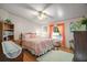 A bright bedroom featuring a comfortable bed, a window with orange curtains, and hardwood floors at 3209 Manatee Rd, Tavares, FL 32778