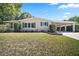 Charming home featuring a covered carport and a well-maintained lawn with lush greenery and manicured shrubs at 3209 Manatee Rd, Tavares, FL 32778