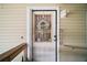Charming front door adorned with a welcoming floral wreath, complemented by well-maintained exterior at 3209 Manatee Rd, Tavares, FL 32778