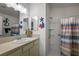 Bright bathroom with decorative fish, vanity, mirror, and a step-in shower with striped curtain at 3222 Miller Stachler St, The Villages, FL 32163