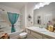 Well-lit bathroom with a tub/shower combo, vanity, mirror, and decorative sea turtle accents at 3222 Miller Stachler St, The Villages, FL 32163