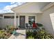 Covered front porch with a seating area, potted plants, and a welcoming entrance at 3222 Miller Stachler St, The Villages, FL 32163