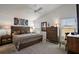 Inviting primary bedroom with a wooden headboard, soft lighting, and decorative pillows and decor at 3222 Miller Stachler St, The Villages, FL 32163