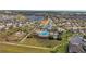 Aerial shot of community with resort-style pool, clubhouse, and playground surrounded by green space at 3256 Canna Lily Pl, Clermont, FL 34711